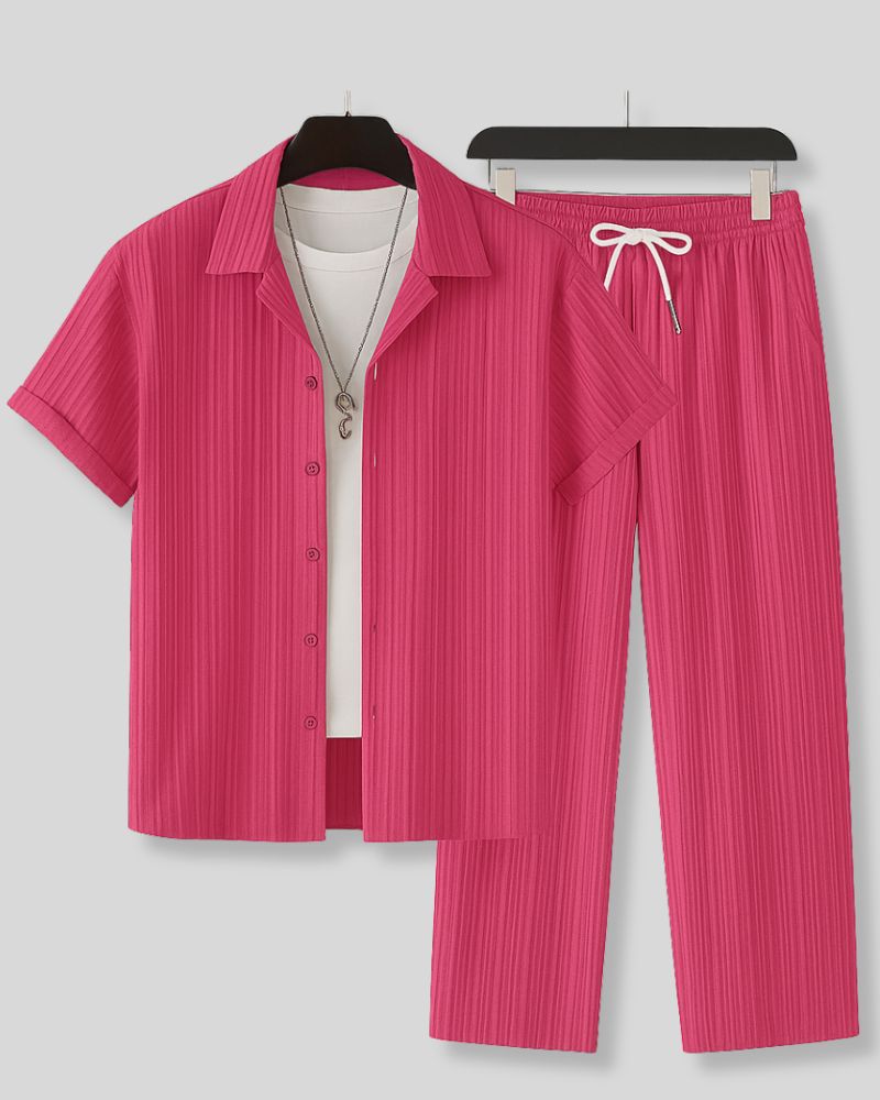 Pink pleated shirt and pants set on hangers against a gray background