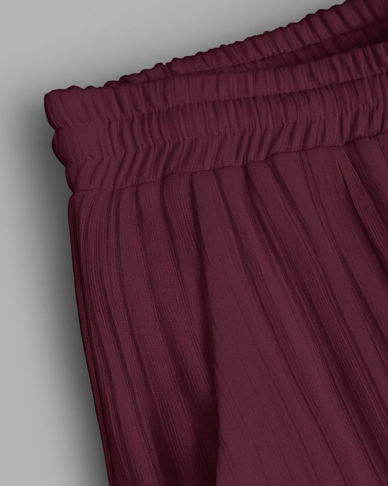 Maroon pants with an elastic waistband on a light gray background