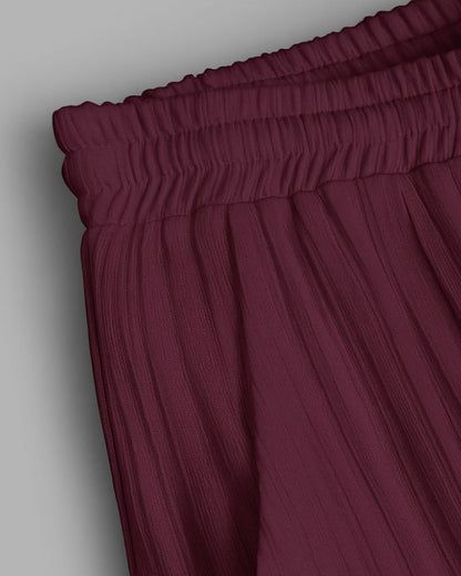 Maroon pants with an elastic waistband on a light gray background