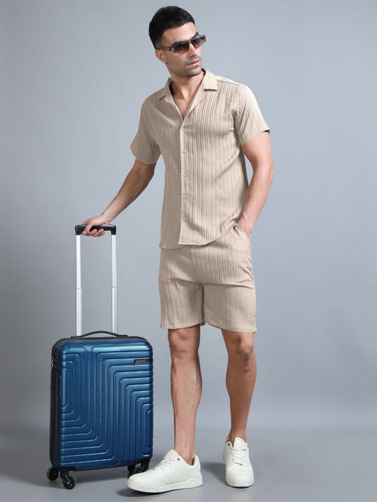 Man in beige co-ord set front view with suitcase